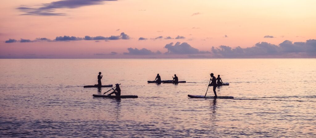 People watching the sunset on a SUP in the sea of Algrave