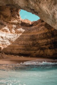 Captivating view of a beach cave in Algarve with turquoise waters and rock formations.
